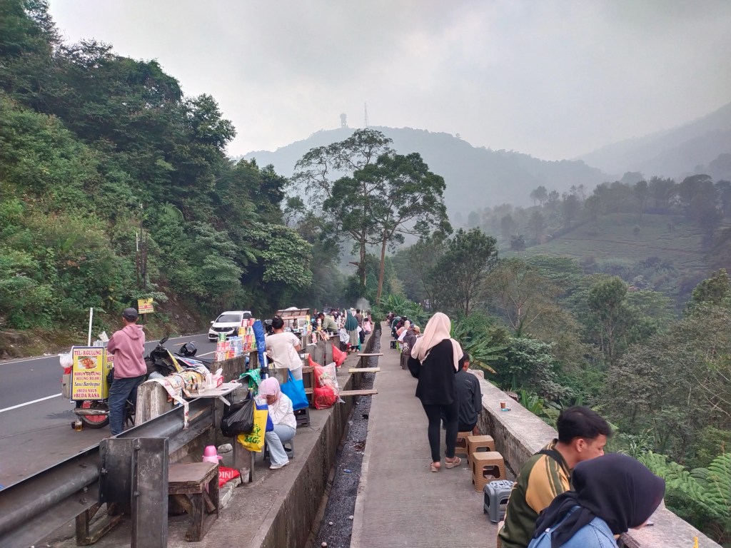 Rest Area Gunung Mas di Puncak, Bogor, yang digadang jadi pusat ekonomi baru, justru sepi pengunjung. Pedagang kaki lima, terutama perempuan, kini terhimpit sewa kios tinggi, pendapatan merosot, hingga ancaman keamanan. Bagaimana mereka bertahan di tengah janji manis relokasi yang tak sesuai kenyataan?